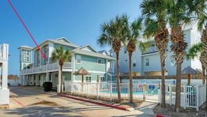 una casa con palmeras delante en Stylish Condo w Pool Spa Access Wak to Beach Beach Breeze by AvantStay, en Port Aransas