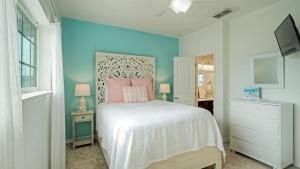 Un dormitorio con una cama blanca y una pared azul. en Stylish Condo w Pool Spa Access Wak to Beach Beach Breeze by AvantStay, en Port Aransas 37 fotos más