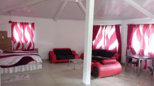 a bedroom with red chairs and a bed and a table at Ecotropicfarmhouse in Cerro Azul