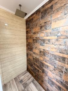 a bathroom with a stone wall and wooden floor at Hostal y Domos Bello Horizonte in Villarrica +35 photos