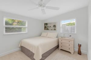 a white bedroom with a bed and two windows at Tropical Pool Haven Minutes to Downtown & beaches in Naples