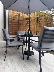 a table with chairs and an umbrella on a patio at Leyand exclusive House in Torre del Lago Puccini
