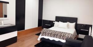a bedroom with a black and white bed and a chair at Casa da Tapada in Torre de Moncorvo