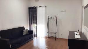 a living room with a black couch and a table at Casa da Tapada in Torre de Moncorvo +16 photos