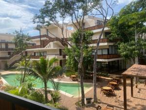 an apartment building with a swimming pool and trees at The Empire in Tulum in Tulum
