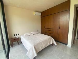 a bedroom with a bed and a wooden cabinet at The Empire in Tulum in Tulum