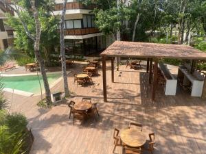an outdoor patio with tables and chairs next to a pool at The Empire in Tulum in Tulum