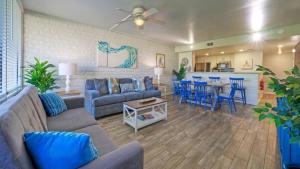 a living room with a couch and a table with chairs at Beach Boardwalk Access Pool Remodeled Interior Tropical Haven by AvantStay in Port Aransas