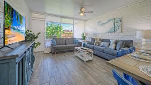 a living room with a couch and a tv at Beach Boardwalk Access Pool Remodeled Interior Tropical Haven by AvantStay in Port Aransas
