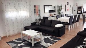 a living room with a black couch and a table at Casa da Tapada in Torre de Moncorvo
