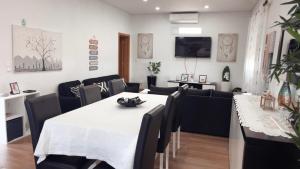 a dining room with a white table and black chairs at Casa da Tapada in Torre de Moncorvo