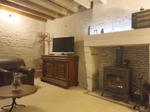 sala de estar con TV y chimenea en Maison isolée avec piscine privée et spa, Charente - FR-1-653-4, en Montignac-le-Coq