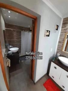 een badkamer met twee wastafels en een spiegel bij Tobias in Villa Gesell +6 foto's