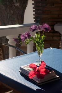 a vase of flowers sitting on a table with a book at Hostal Mar de Frente in Los Caños de Meca