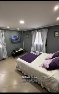 een slaapkamer met een groot bed en een tv bij Tobias in Villa Gesell