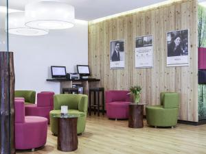 a waiting room with colorful chairs and pictures on the wall at Mercure Hotel am Messeplatz Offenburg in Offenburg