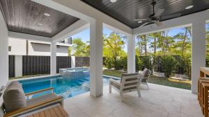 an outdoor living room with a swimming pool and a patio at Priv Heated Pool Spa Golf Cart Included 7BDR Sleeps 20 30A Serenity Sands in Santa Rosa Beach
