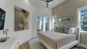 a bedroom with a bed in a room with windows at Priv Heated Pool Spa Golf Cart Included 7BDR Sleeps 20 30A Serenity Sands in Santa Rosa Beach +40 photos