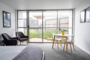 a room with a bed and a table and chairs at Bay View Breeze in Lorne