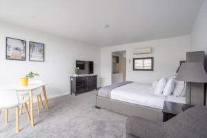 a bedroom with a bed and a table and a tv at Bay View Breeze in Lorne +11 photos