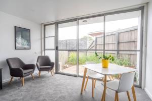 a living room with a table and chairs and a window at Bay View Breeze in Lorne