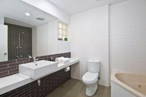 a bathroom with a sink and a toilet and a tub at Bay View - The Trio in Lorne +10 photos