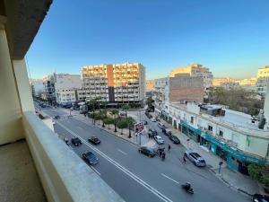 Una vista de una calle de la ciudad con coches y edificios. en 3Bed-Room City Centre Apartment - 3 min to Train Station, en Fez