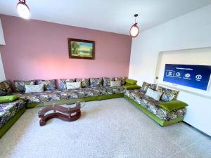 una sala de estar con un sofá y una mesa en 3Bed-Room City Centre Apartment - 3 min to Train Station, en Fez