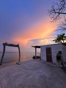 a building on the beach with a sunset in the background at Puerto idilio beach resort in Isla Grande