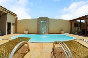 Una gran piscina con dos sillas y una fuente. en Vale Confort Hotel, en Petrolina