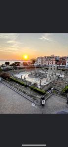 een uitzicht op een stad met de zonsondergang op de achtergrond bij B&b Carlotta in Pozzuoli