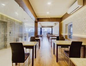 a row of tables and chairs in a restaurant at Super Townhouse OAK Seventy Seven in Dum Dum