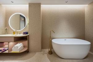 a bathroom with a white tub and a sink at Qingzhou Ancient City Minxin Hotel in Qingzhou
