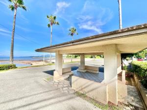 un pabellón en la playa con palmeras y el océano en AMANA Villa 101, en Amakusa