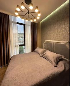 a bedroom with a large bed with a window at Nice Stay Near Center in Yerevan