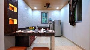 eine Küche mit Theke und Kühlschrank in der Unterkunft Zenzi Stays 11 BHK With 2 Pools in Khandāla
