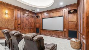 Infinity Pool Theater Pickleball 360 Views Near Lake Poway Sunset Point Estate by AvantStay في رانشو برناردو: غرفة معيشة بجدران خشبية وشاشة تلفزيون كبيرة +73 صورة