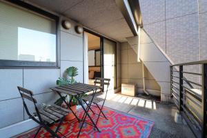 a balcony with a table and chairs in a building at Al Di La 四谷 in Tokyo