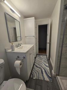 ein Badezimmer mit Waschbecken, Toilette und Spiegel in der Unterkunft Upper-Level Oasis- Ideal for 2026 World Cup visitors in Norwood + 24 Fotos