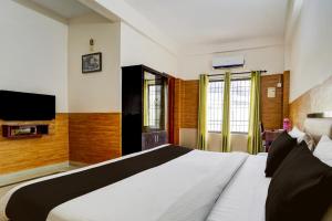 una camera da letto con un letto grande e una TV di Hotel O Bharata Mata College Kakkanad a Kakkanad Altre 23 foto