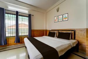 una camera da letto con un letto grande e una finestra di Hotel O Bharata Mata College Kakkanad a Kakkanad