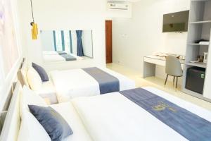 a hotel room with two beds and a desk at 6668 Hotel - Chi nhánh 2 in Tây Ninh