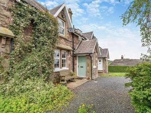 an exterior view of a brick house with a green door at 2 Bed in Mindrum oc-50973 in Crookham