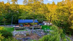 a house in the woods with a blue roof at Modern Catskills Escape w Open Living Steam Shower Hot Tub w Mountain Views Minutes from Woodstock Trails Suncliff Vista in Shokan