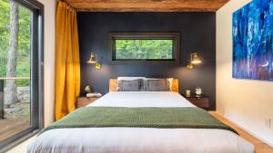 a bedroom with a large bed and a window at Modern Catskills Escape w Open Living Steam Shower Hot Tub w Mountain Views Minutes from Woodstock Trails Suncliff Vista in Shokan