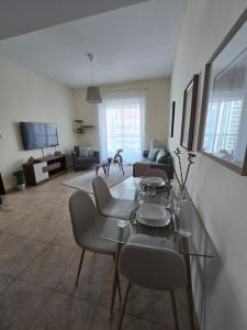 a living room with a glass table and chairs at Dar Al Noor Apartment in Dubai