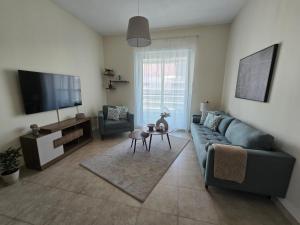 a living room with a couch and a flat screen tv at Dar Al Noor Apartment in Dubai