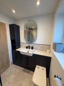 a bathroom with a sink and a toilet and a mirror at Luxury House, Great Location in Redditch - Contractors - Families - Groups - Relocators - Sleeps 9 in Bentley +32 photos