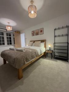 a bedroom with a large bed and a lamp at Luxury House, Great Location in Redditch - Contractors - Families - Groups - Relocators - Sleeps 9 in Bentley