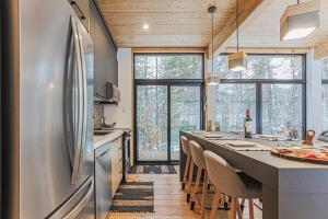eine Küche mit Kühlschrank und einem Tisch mit Stühlen in der Unterkunft Chic & Bois in La Conception